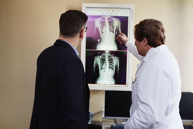 Osteopath explaining Sciatica pain on xray inside a clinic in Singapore