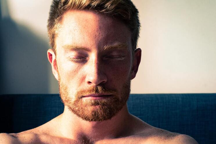 man with ginger facial features with eyes closed meditating