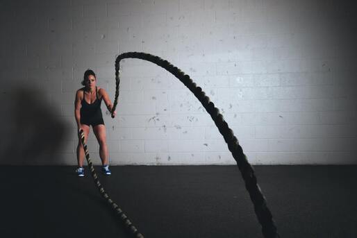 female caucasian athlete doing battle rope 